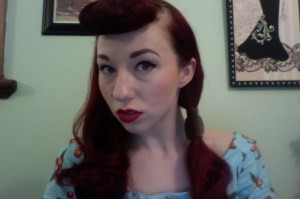 Hair divded down the middle, with one side pinned away with a curler clip. 